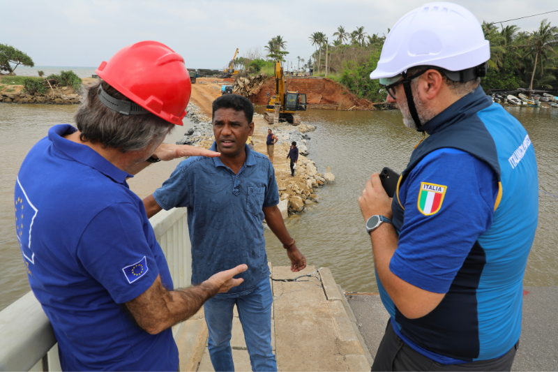 1operatore del Dipartimento e 1 operatore del meccanismo europeo di protezione civile in primo piano di spalle mentre parlano con una persona del posto in Sri Lanka